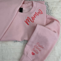 a pair of pink sweatshirts sitting on top of a bed
