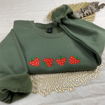 a green sweatshirt with strawberries on it