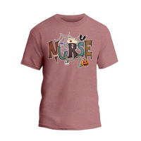 A pink t-shirt with the word "NURSE" written in a creative and colorful design, featuring various Halloween-themed elements such as a spider web, bats, a jack-o-lantern, and a nurse's cap.