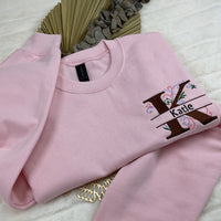a pink sweatshirt with a tree on it