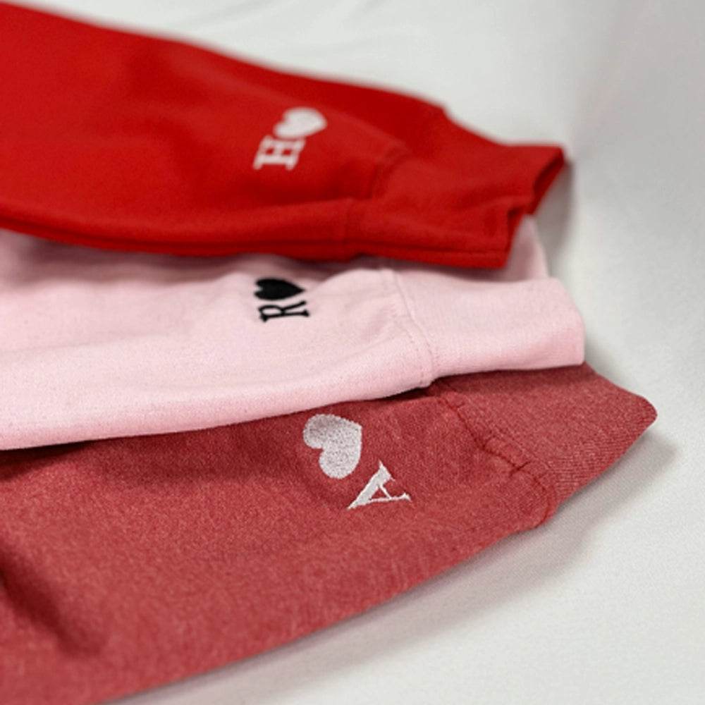 a group of three red and pink shirts sitting on top of a white table