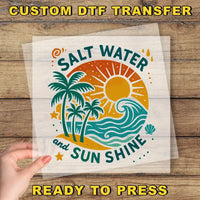 a hand holding a clear plastic sheet with a colorful graphic design of a beach scene, including palm trees, a sun, and waves.