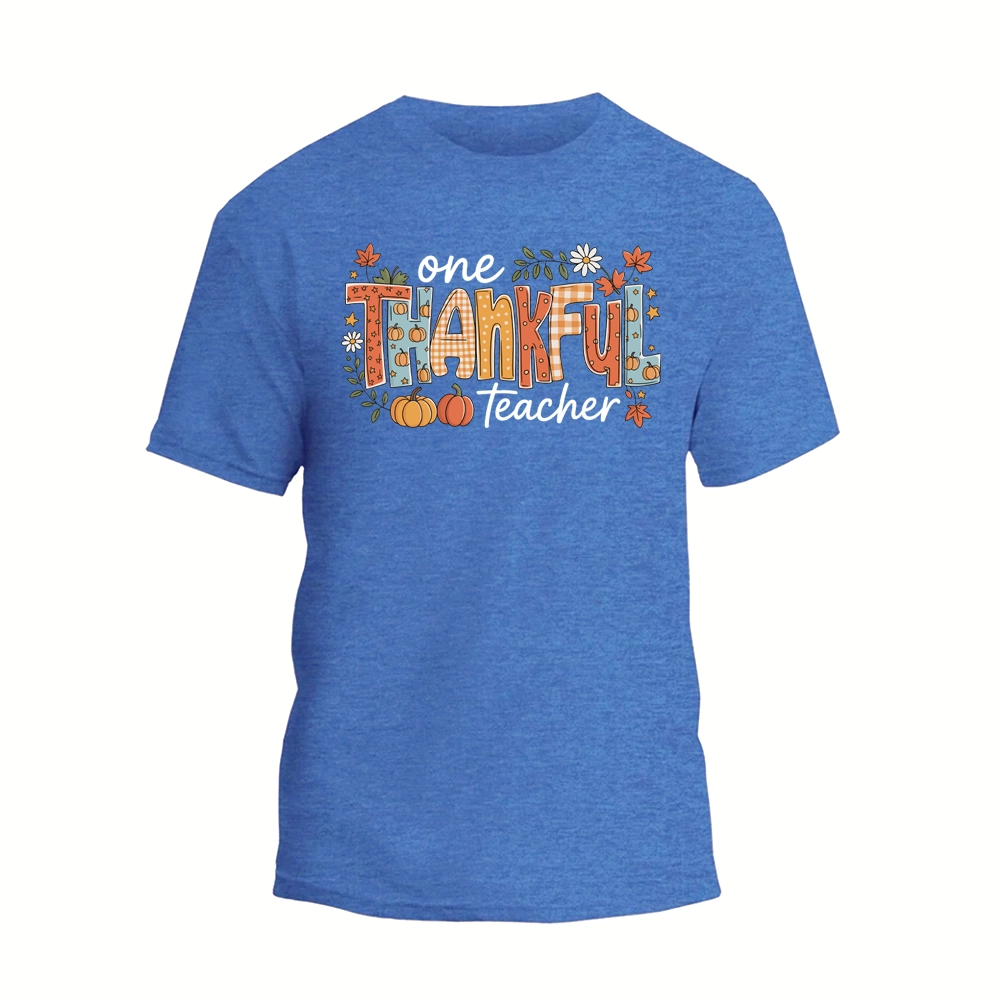 A blue t-shirt with a graphic design featuring the text "One Thankful Teacher" surrounded by various fall-themed elements such as pumpkins, leaves, and flowers.