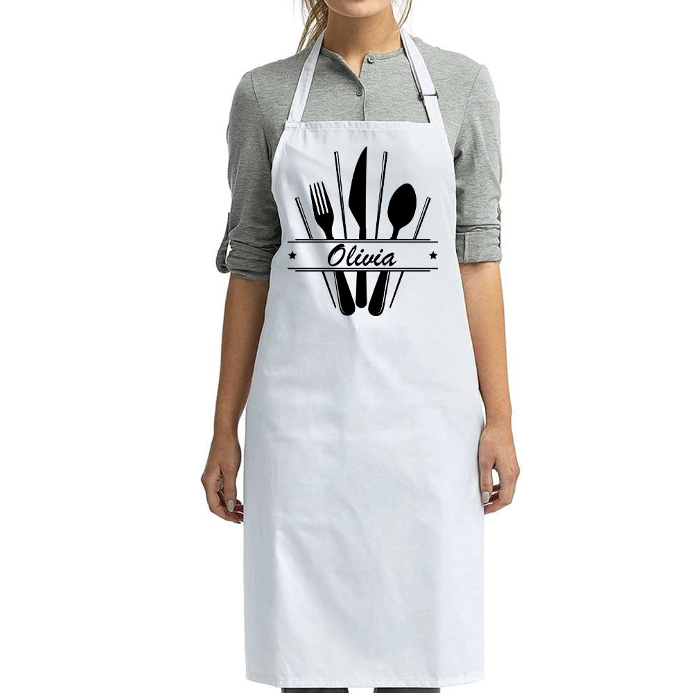 a woman wearing a white apron with black utensils