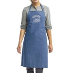 a woman wearing a denim apron with a custom logo on it