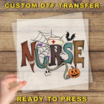 The image is a hand holding a piece of paper with the word "NURSE" written on it, along with various Halloween-themed elements such as a spider web, a bat, a pumpkin, and a skeleton.