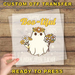 a hand holding a paper with a picture of a ghost on it