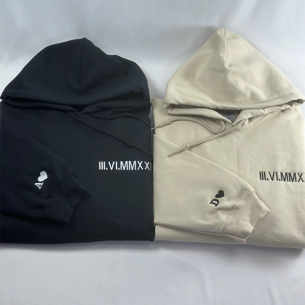 a white and a black hoodie laying next to each other