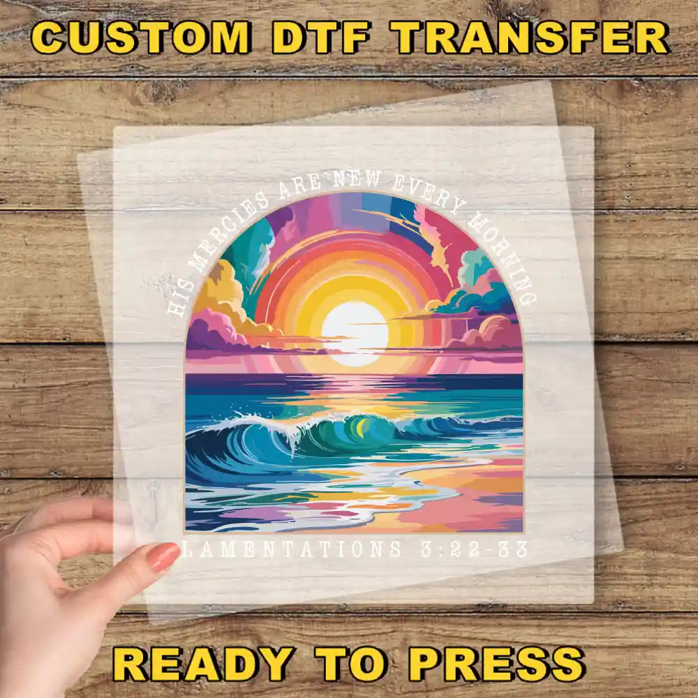The image is a hand holding a transparent sheet with a colorful illustration of a sunset over a body of water.