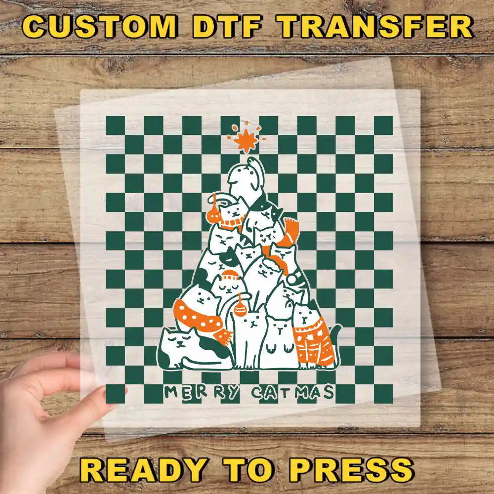 A hand is holding a transparent sheet with a Christmas tree design on it, which is set against a wooden background.