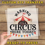a person holding up a sign with a circus tent in the background
