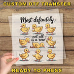 The image is a hand holding a transparent sheet with a cartoon illustration of a row of yellow ducks. The text on the sheet reads "Most definitely not all is a row", and the phrase "READY TO PRESS" is also visible.