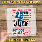 a hand holding a piece of paper with a patriotic design, including a hot dog and fireworks, along with text that says "You look like the 4th of July makes me want a hot dog real bad!".