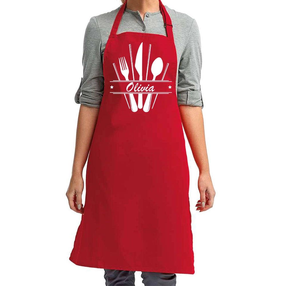 a woman wearing a red apron with utensils on it